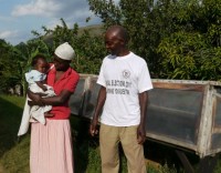 Fairtrade.banana.producer.David.Mugabi.with.wife.Dorothy.and.baby.in.front.of.solar.driers
