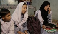 Worker, Liaqat’s 3 children showing off their free school books and backpacks. They want to be teachers and a doctor when they grow up. With Fairtrade they’re a step closer to achieving their goals.